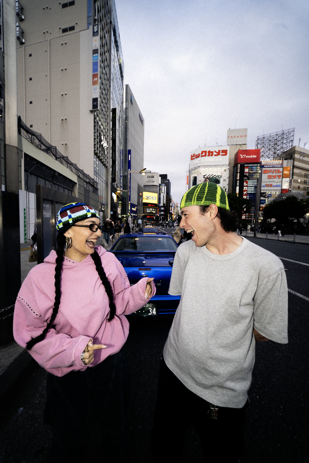 Deux modèles complices dans une rue de Tokyo, bonnets crochetés